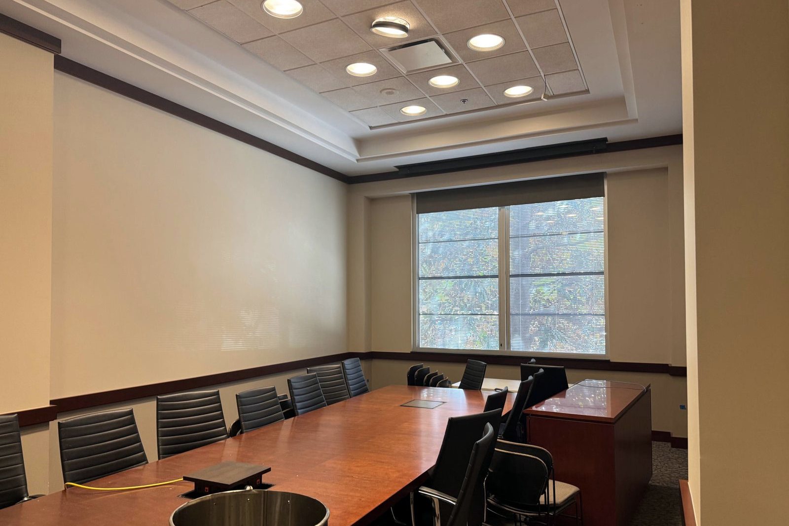 Conference room with painted walls, dark wood trim, and a coffered ceiling